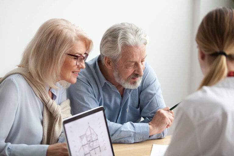 Older couple reading contract at meeting with real estate agent