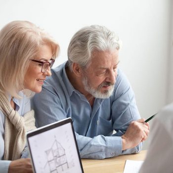 Older couple reading contract at meeting with real estate agent